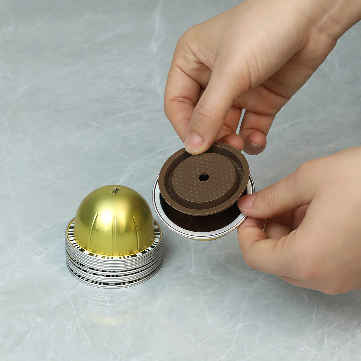 Gold reusable coffee capsule set, fitted with tamper, cleaning brush, spoon and silicone lid.
