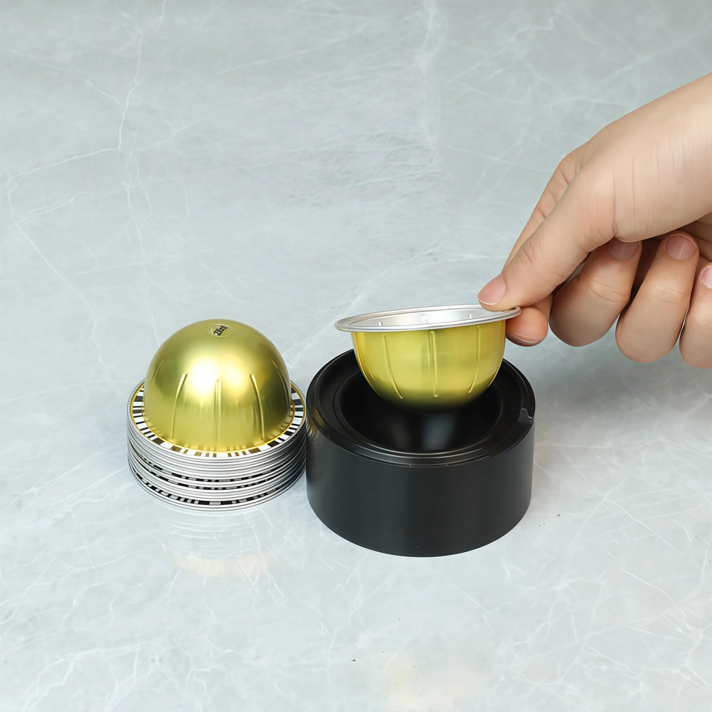 Gold reusable coffee capsule set, fitted with tamper, cleaning brush, spoon and silicone lid.
